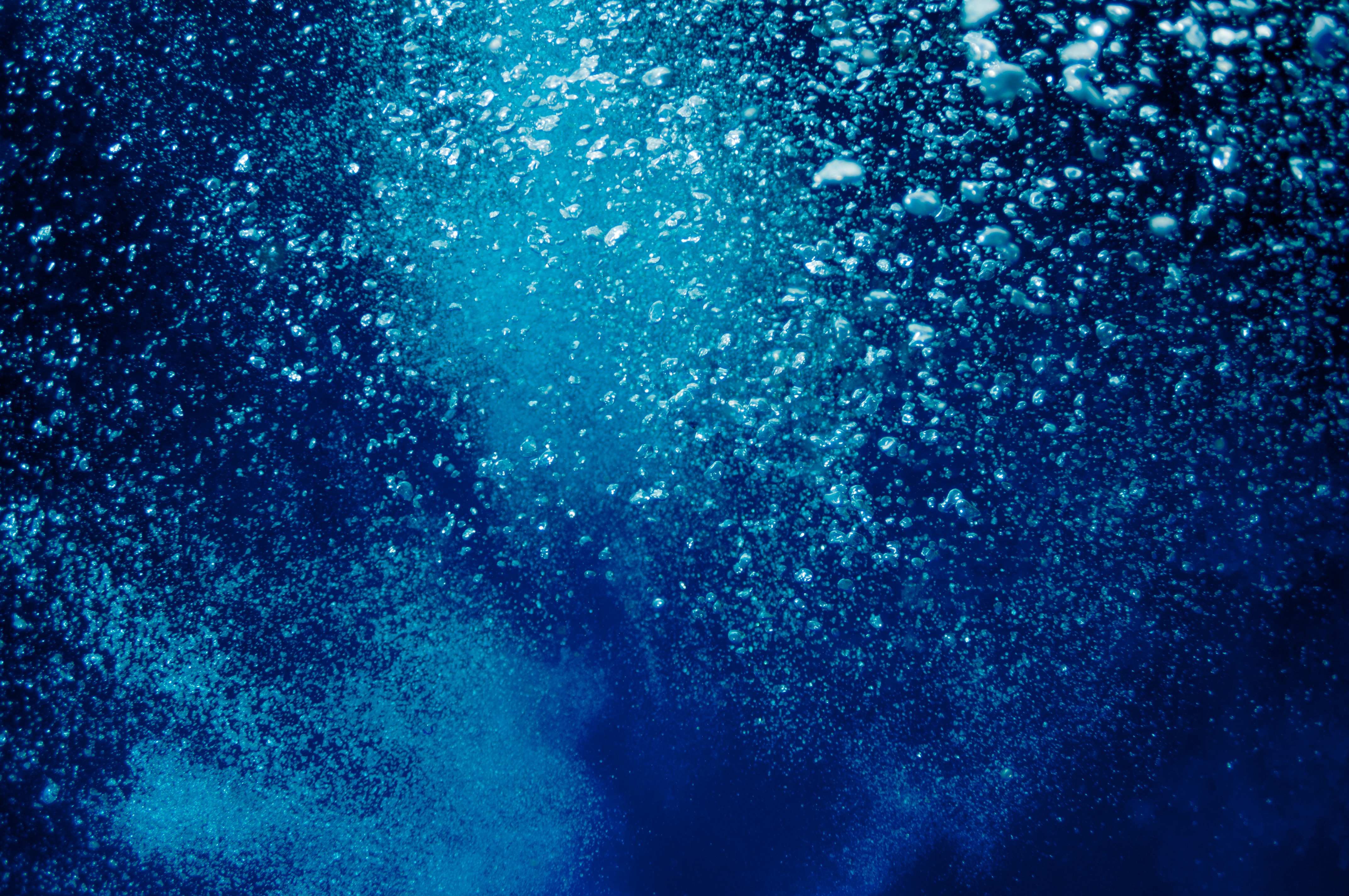 The picture shows underwater bubbles which raise from the depth of blue sea; Shutterstock ID 121975975